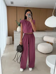 Trendy two-piece set featuring padded shoulder sleeveless crop top and wide-leg pants.