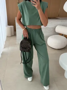 Detailed view of sage green two-piece set featuring padded shoulder top and wide-leg trousers