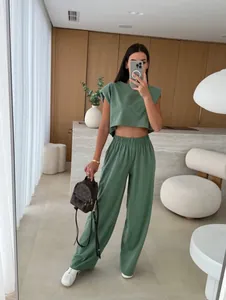 Sage green two-piece set featuring a padded shoulder sleeveless crop top and wide-leg pants.
