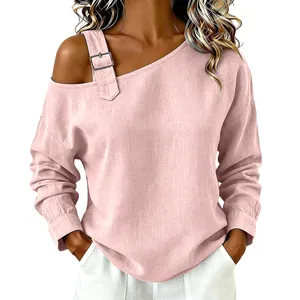Primer plano de una blusa de lino rosa con un hombro y detalle de hebilla ajustable