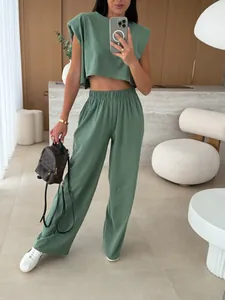 Detail of sage green two-piece set featuring padded shoulder top and high-waist pants.