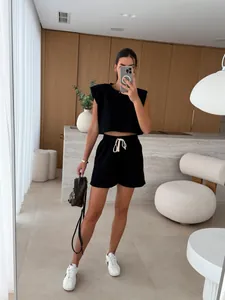 Macro view of black two-piece set featuring padded shoulder top and casual shorts.