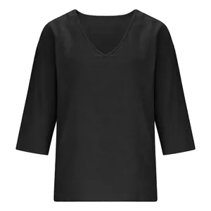Macro view of the V-neckline and textured bamboo cotton fabric on this loose black top.