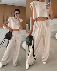 Close-up of beige two-piece set featuring padded shoulder top and wide-leg trousers