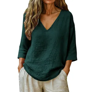 Detail view of a stylish dark green women's loose V-neck top made of soft slub cotton fabric