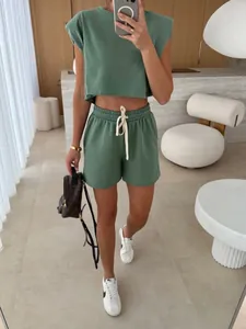 Detail view showing the fit of a sage green shoulder-padded top and shorts set.