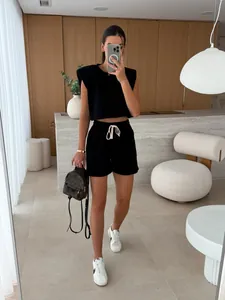 Chic women's black two-piece set with padded shoulder sleeveless top and matching shorts