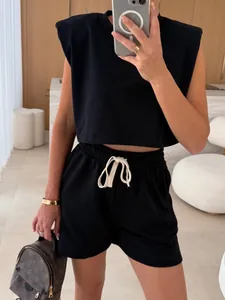 Close-up detail of black padded shoulder sleeveless crop top and matching shorts set