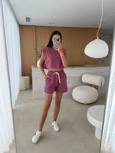 Detail view of mauve padded shoulder sleeveless top and matching shorts on model