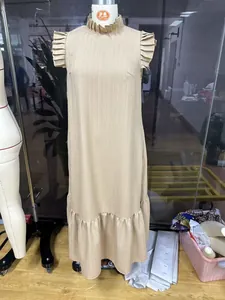Vista completa de vestido largo beige holgado con mangas con volantes en un maniquí de sastre