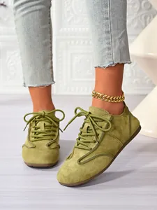 Detailed shot of lime green suede casual flats with laces and a stylish gold anklet accessory