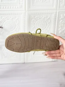 Close-up of non-slip outsole detail on green casual women's moccasin shoe