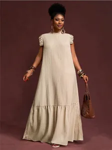 Vista detallada del diseño de mangas con volantes en el vestido maxi plisado beige talla grande