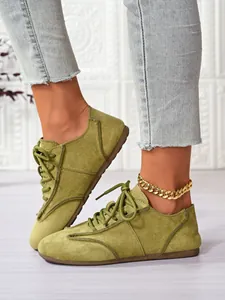 Close-up of olive green suede lace-up casual shoes with textured stitching detail