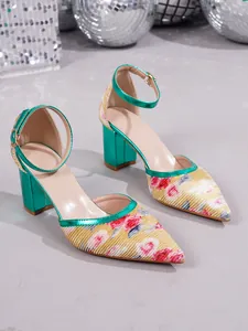 Close-up of pointed toe pumps with floral print and metallic green block heel