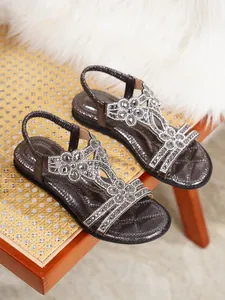 Detail of bohemian flat sandals with sparkling rhinestone flower embellishments.