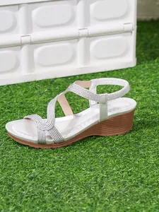 Silver bohemian wedge sandals with crisscross straps and textured finish