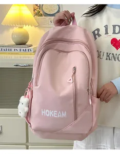 Close-up of stylish pink large-capacity school backpack with a cute plush bear keychain