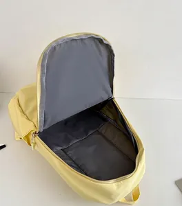 Detailed view of the spacious internal capacity and grey lining of the yellow backpack.