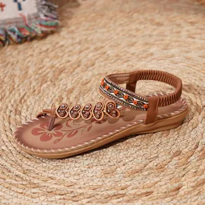 Detailed view of bohemian beaded thong sandals with ethnic embroidery and heart accents.