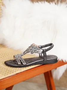 Close-up of bohemian silver flat sandal featuring intricate rhinestone floral details