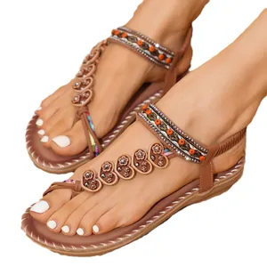 Close-up view of Bohemian flat sandals featuring ethnic beadwork and floral charms on the straps.