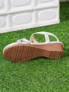 Detailed view of the non-slip rubber outsole on a silver bohemian wedge sandal
