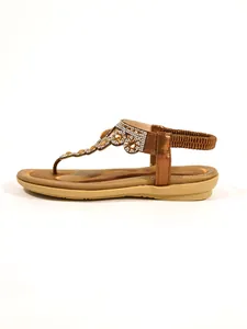 Detail view of bronze thong sandals featuring sparkling rhinestone flower accents