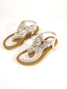 Detailed view of women's flat sandals with sparkling flower rhinestone embellishments