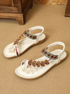 Detailed shot of Bohemian ethnic flat sandals with intricate beading and heart accents