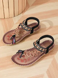 Detailed view of bohemian flat sandals with intricate beadwork and floral patterns