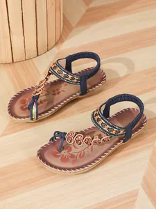 Detailed view of bohemian beach sandals featuring intricate beadwork and floral patterns.
