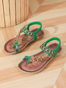 Bohemian flat sandals featuring green elastic straps and intricate floral beaded details