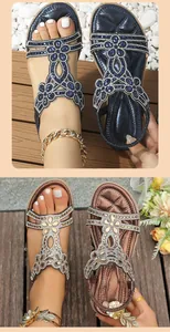 Detailed view of bohemian flat sandals featuring intricate rhinestone flower patterns.
