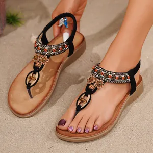 Böhmische flache T-Steg-Sandalen mit aufwendigen Blumenperlen und Strass auf Sandstrand