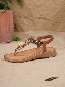 Detailaufnahme der braunen flachen Bohemian-Sandale mit Perlen und Strass