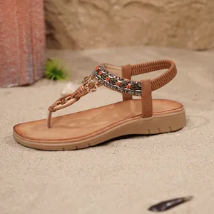 Böhmische braune flache T-Steg Sandalen mit Perlen und Strass auf feinem Sandstrand