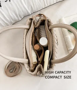 Detailansicht einer beigen geflochtenen Tasche mit großem, organisiertem Innenraum