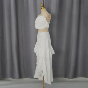 Vue latérale d'un ensemble deux pièces blanc avec haut à fleurs 3D et jupe en dentelle.