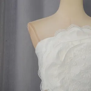 Détail de la fleur en dentelle 3D complexe sur un haut de vacances blanc sans bretelles