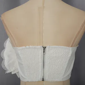 Vue arrière détaillée d'un haut bustier blanc avec fermeture éclair et smocks.