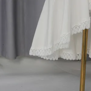 Gros plan sur le détail élégant de la broderie en dentelle blanche sur l'ourlet de la jupe
