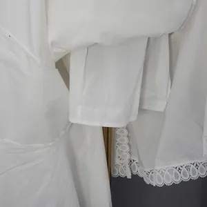 Gros plan sur l'ourlet d'une robe blanche avec dentelle délicate et doublure