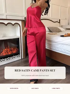 Close-up of red satin cami and long pants set with delicate black lace trim details