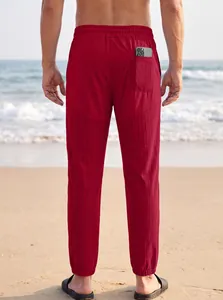 Vista trasera de pantalones deportivos rojos para hombre con bolsillo en la playa