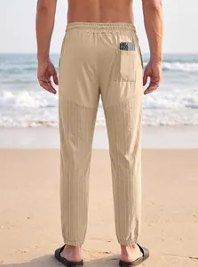 Vista trasera de pantalones jogger caqui para hombre con bolsillo trasero en la playa