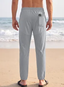 Vista trasera de joggers grises para hombre con textura y bolsillo trasero en la playa
