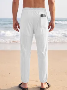 Vista trasera de pantalones blancos casuales para hombre con detalle de bolsillo en playa