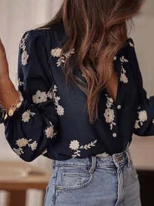 Detail view of navy blue embroidered floral blouse with puff sleeves and buttons