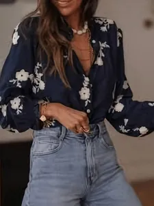 Detailed close-up of navy blue floral embroidered blouse with puff sleeves and ruffle collar